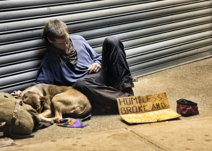 New York, USA - May 16, 2013: homeless man sleeping with dog on sidewalk on 8th Ave and 42th Street, Manhattan, NY.