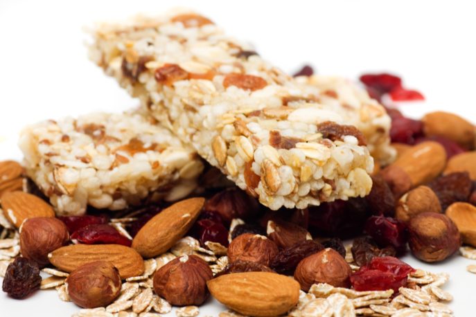 Granola bar with dried fruit and nuts on white background