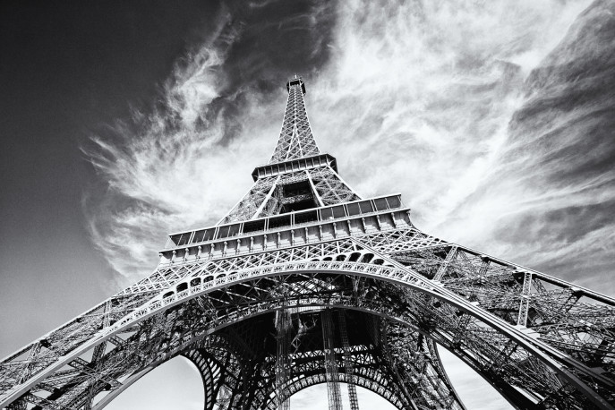 Dramatic view of Eiffel Tower in Paris, France. Black and white image, same film grain added.