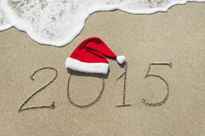 happy new year 2015 with christmas hat on sandy beach with wave - holiday concept
